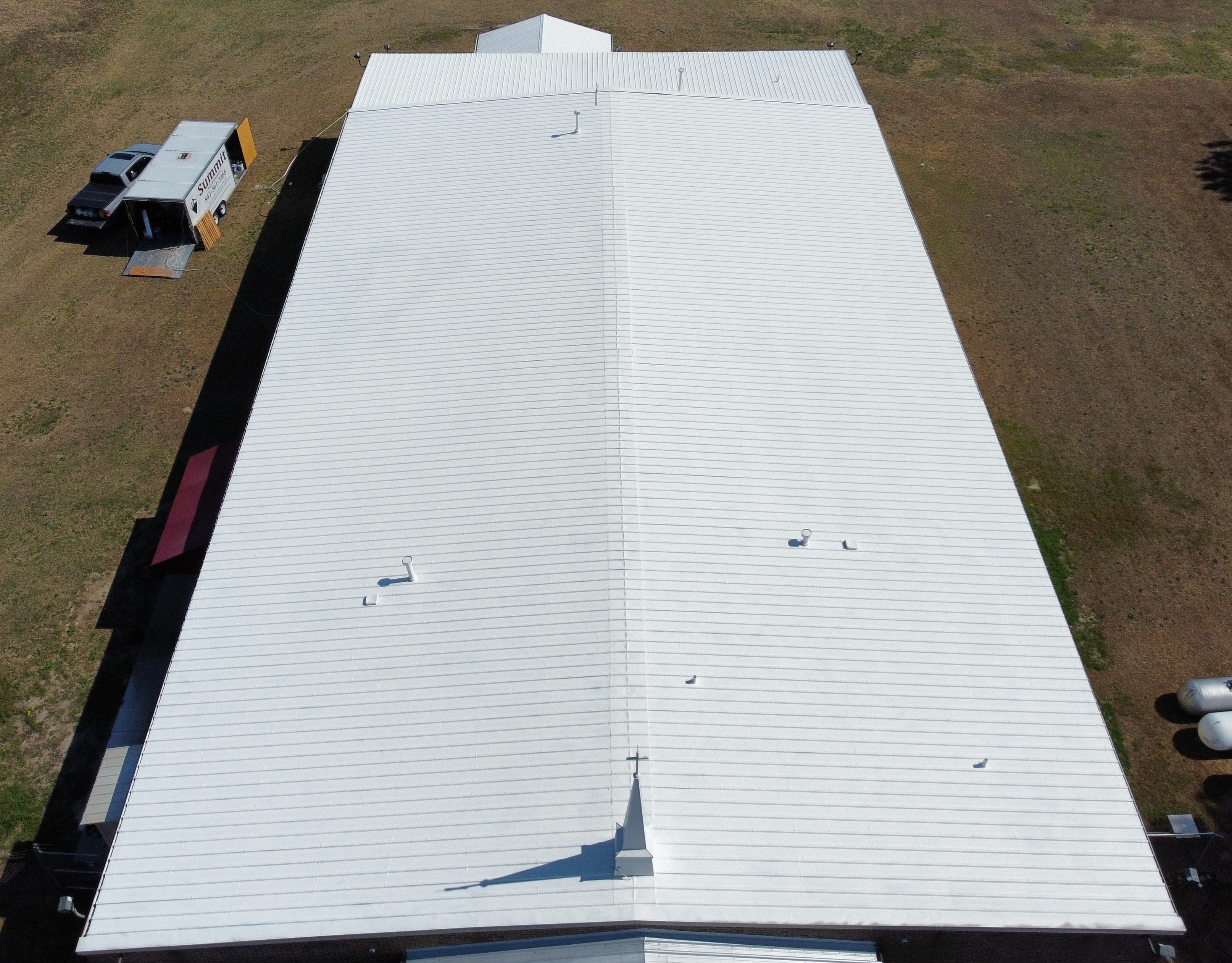 Lumber Bible Church completed roof coating — parking lot and steeple visible