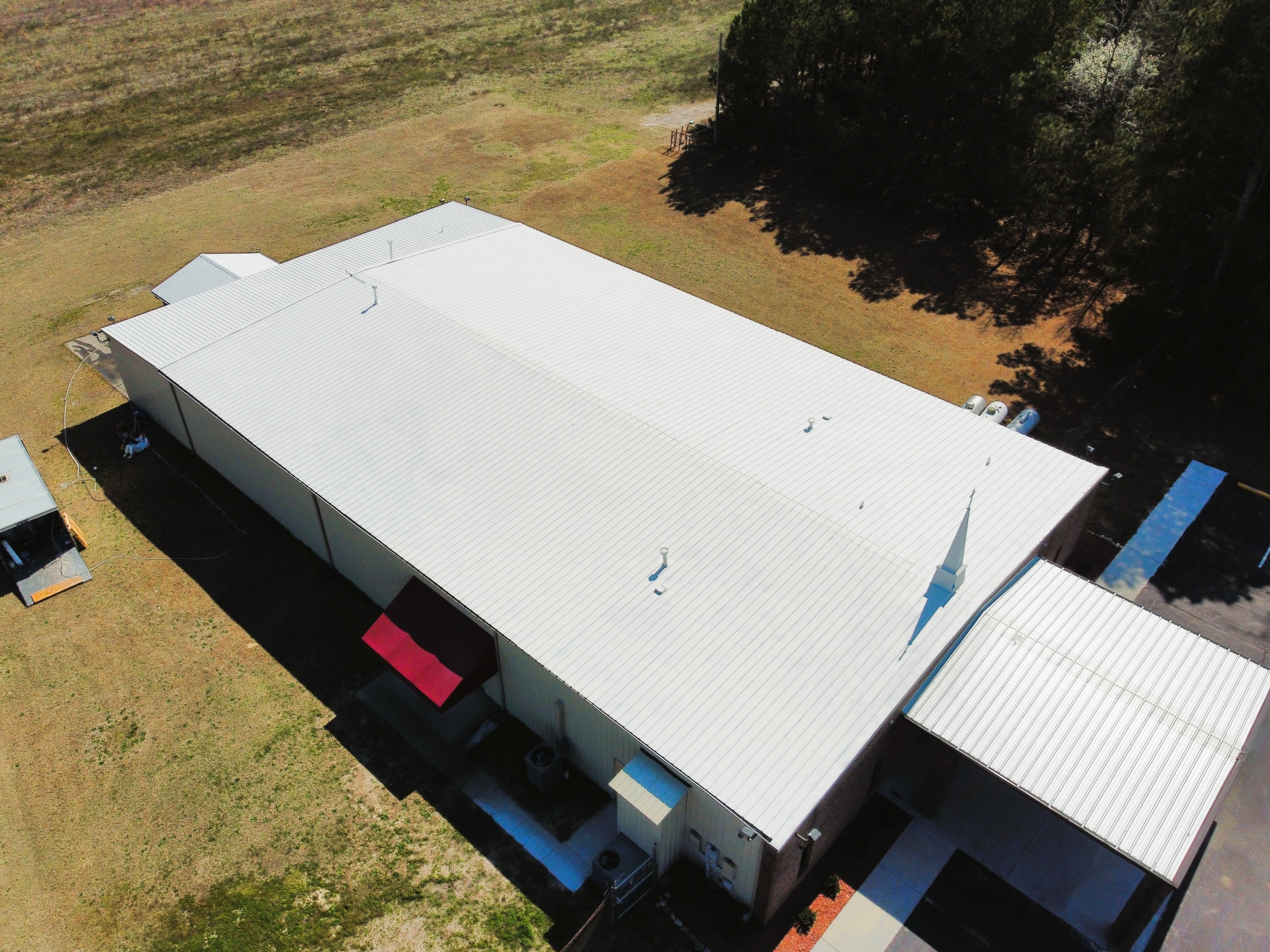 Lumber Bible Church finished white roof — full building aerial view