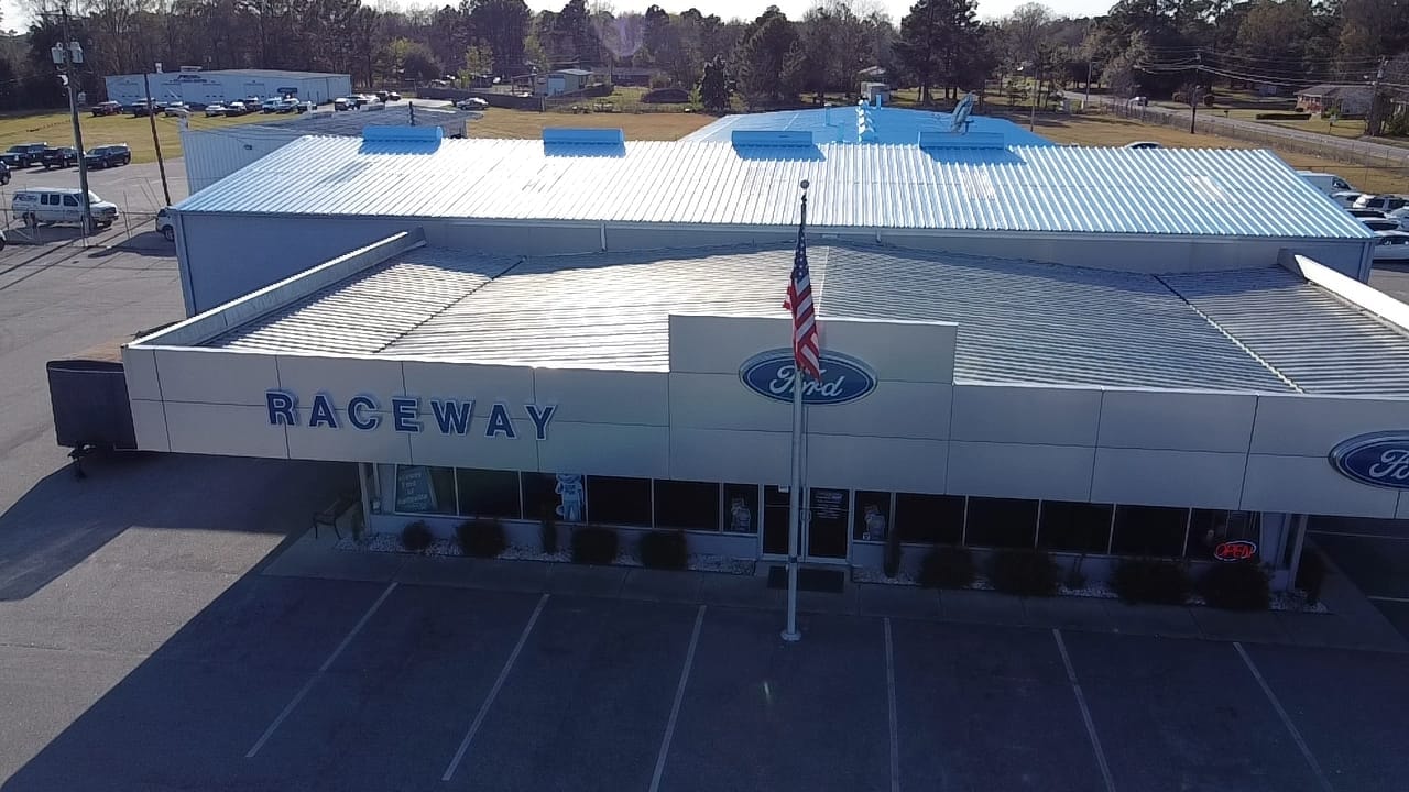 Raceway Ford of Darlington roof before coating — weathered metal surface aerial view